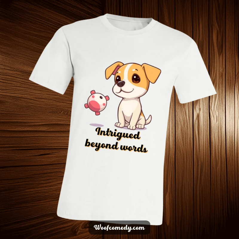 Funny t-shirt of a curious dog tilting its head, eyes locked onto a floating squeaky toy.